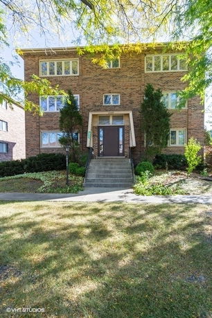 Front view of a multi-story brick building with symmetrical windows.