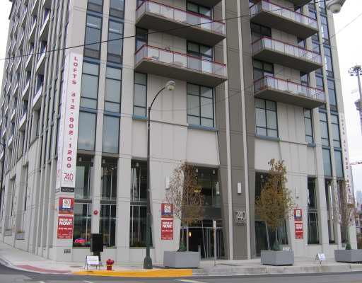 Front view of a multi-story residential building with balconies and large windows.