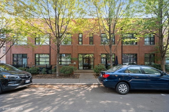 Front view of a two-story brick building with large windows.