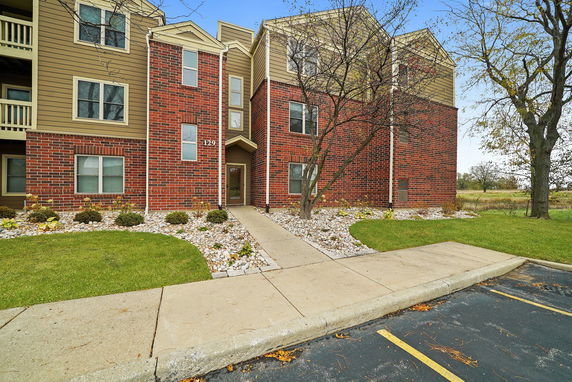 Front view of a multi-story brick and siding apartment building.