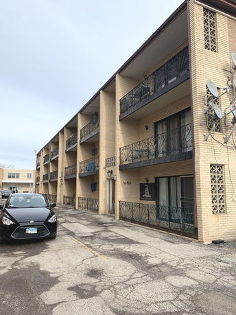 Front view of a brick apartment building with balconies.