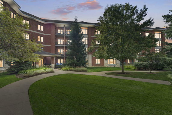 Front view of a three-story building with a brick exterior and multiple windows.