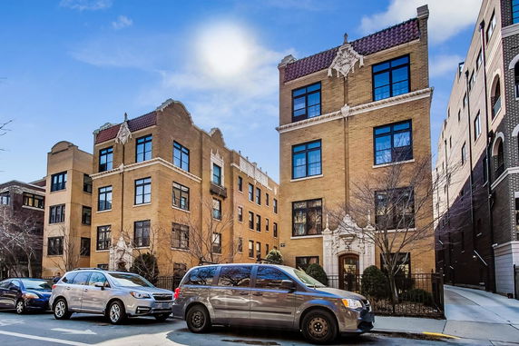Front view of a multi-story brick building with decorative elements.