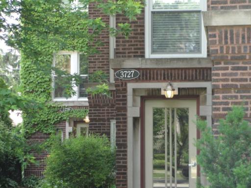 Front view of a brick house with an address displayed above the entrance.