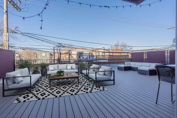 Rooftop with outdoor seating and string lights.
