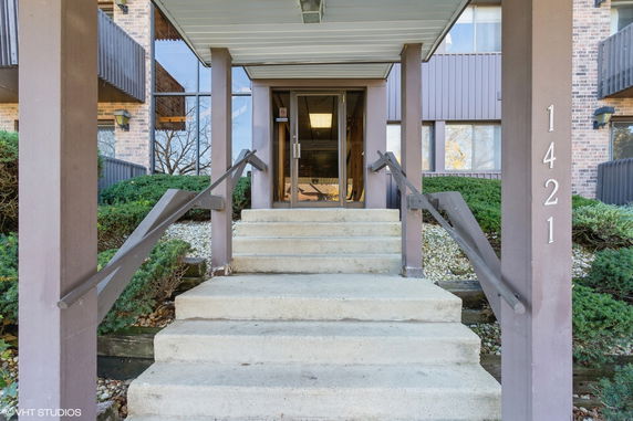 Entrance of a building with concrete steps and glass doors.