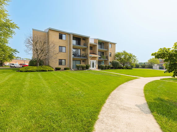 Front view of a three-story apartment building with balconies.