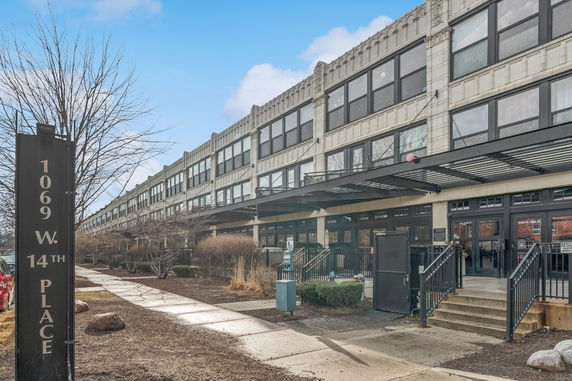 Front view of a large multi-story building with glass windows and multiple entrances.