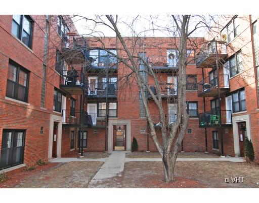 View of a multi-story brick apartment building with balconies.
