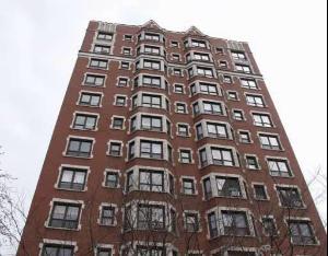 Front view of a multi-story brick building with numerous windows.