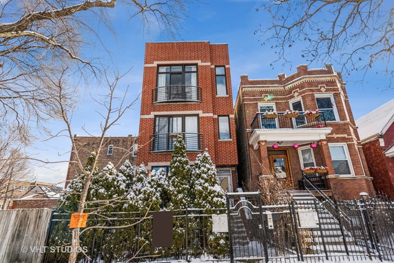 Front view of two multi-story brick buildings with balconies.