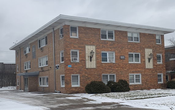 Front view of a three-story brick apartment building.