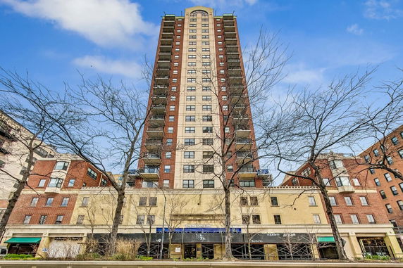 Front view of a tall multi-story building with balconies.