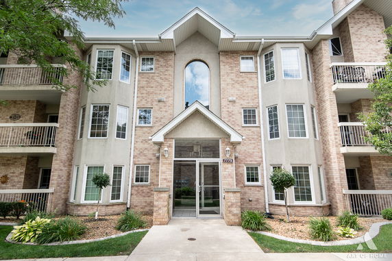 Front view of a multi-story building with brick and stucco facade.