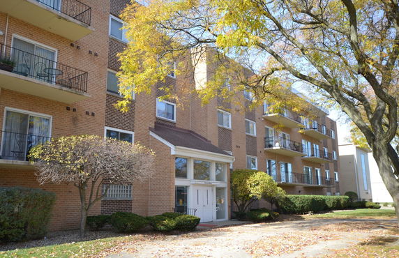 Front view of a multi-story apartment building with balconies.