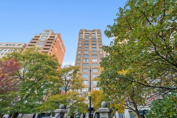 Front view of a tall residential building with multiple floors and large windows.