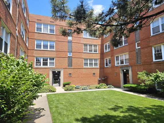 Front view of a multi-story brick apartment building.
