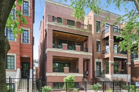 Front view of a multi-story brick building with balconies