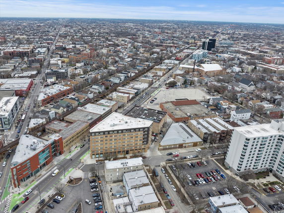 Wide aerial view of a cityscape with numerous buildings and roads stretching out towards the horizon.