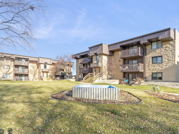 Front view of a multi-story apartment building with balconies.