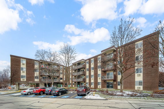Front view of a multi-story apartment building with balconies.
