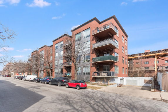 Front view of a multi-story apartment building with balconies.