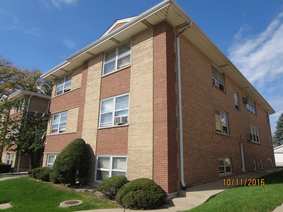 Front and side view of a multi-story building with brick exterior.