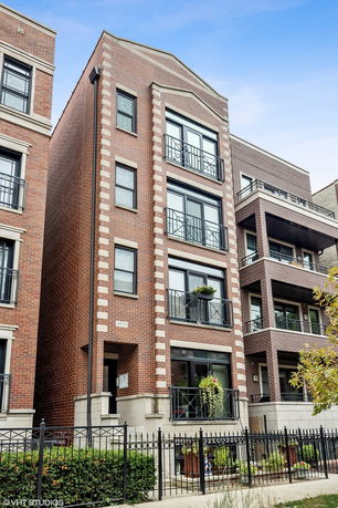 Front view of a multi-story brick building with balconies.