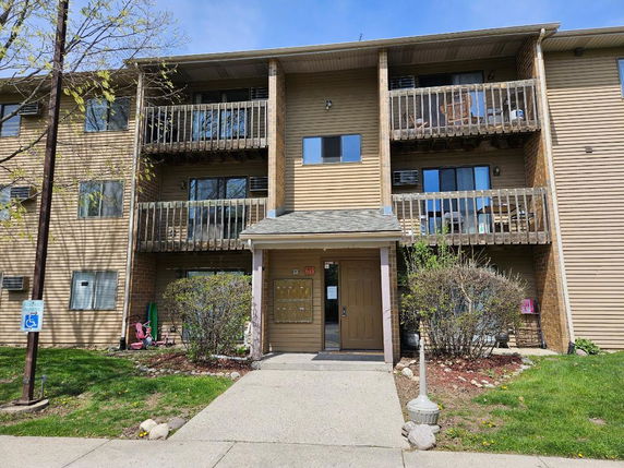 Front view of a multi-story apartment building with balconies.