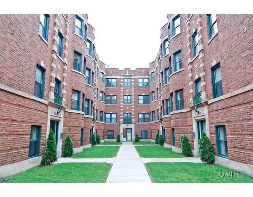 Front view of a multi-story brick apartment building with an entrance set between two symmetrical wings.
