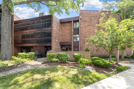 Front view of a multi-story brick building with balconies.