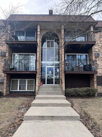 Front view of a multi-story brick building with balconies.