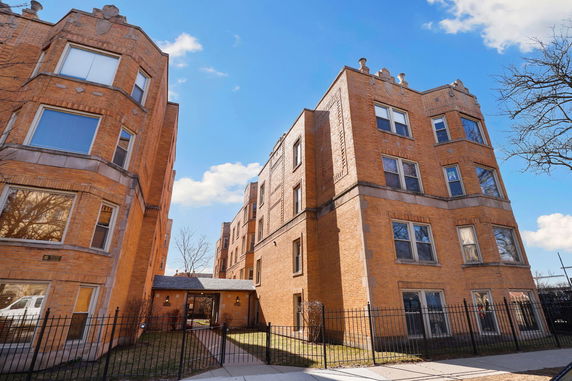 Front view of a brick apartment building with multiple stories.