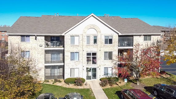 Front view of a three-story apartment building with a pitched roof.
