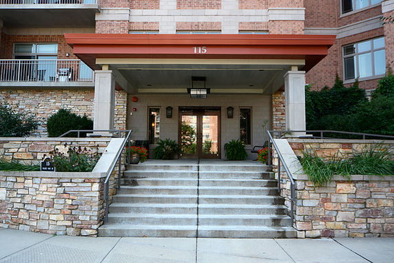 Front view of a building entrance with stone steps and brick facade.