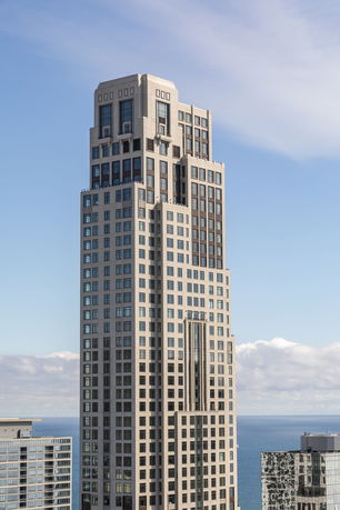 Front view of a tall skyscraper with multiple windowed levels.