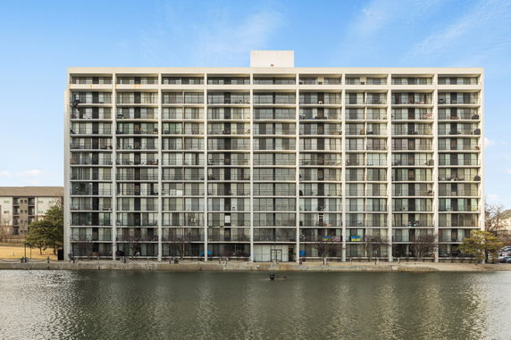 Front view of a multi-story apartment building with a grid-like window pattern.