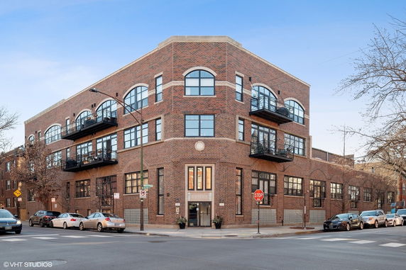 Front view of a multi-story brick building with balconies.