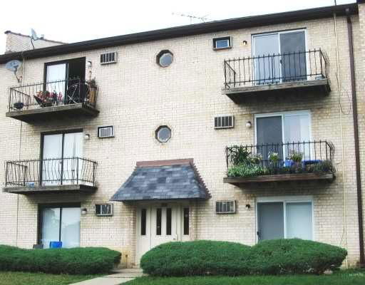 Front view of a three-story apartment building with balconies.