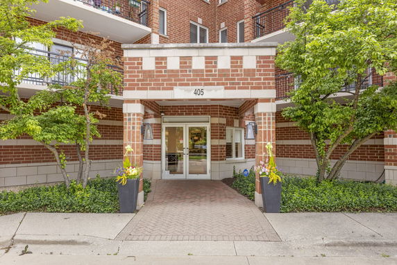 Front view of a multi-story brick building with entrance and balconies.