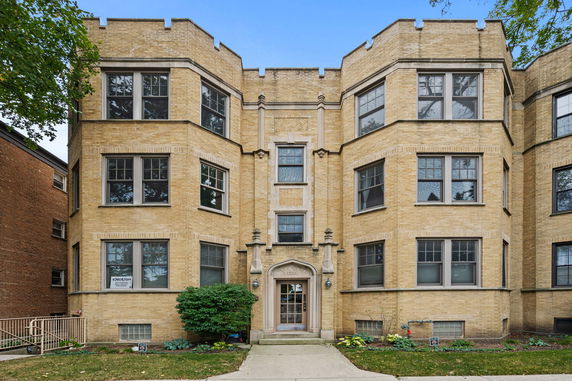 Front view of a multi-story brick building with multiple bay windows.