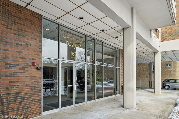 Front view of a building entrance with large glass windows and brick exterior.