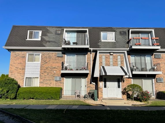 Front view of a three-story residential building with balconies.