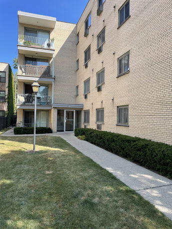 Front view of a multi-story apartment building with balconies.
