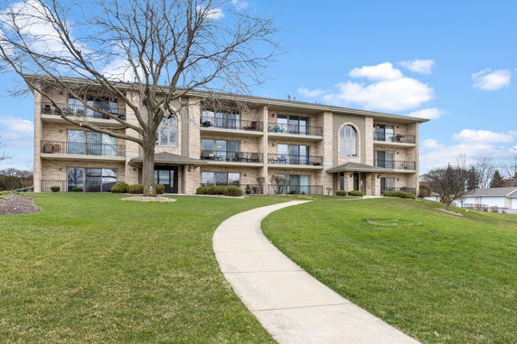 Front view of a three-story residential building with balconies.