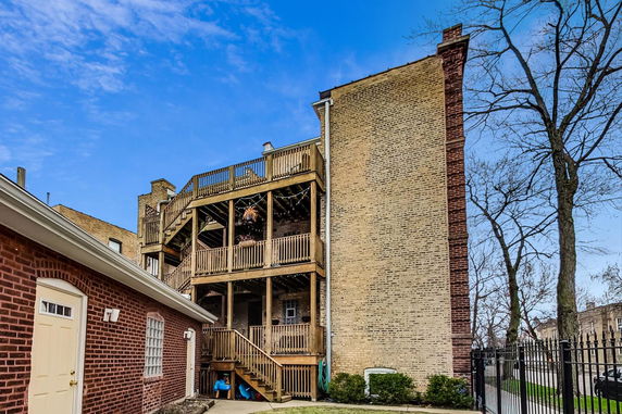 Rear view of a multi-story brick building with wooden balconies.