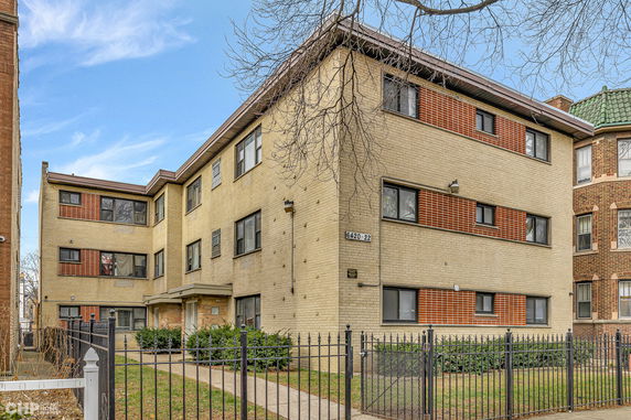 Front view of a three-story apartment building with a brick facade.