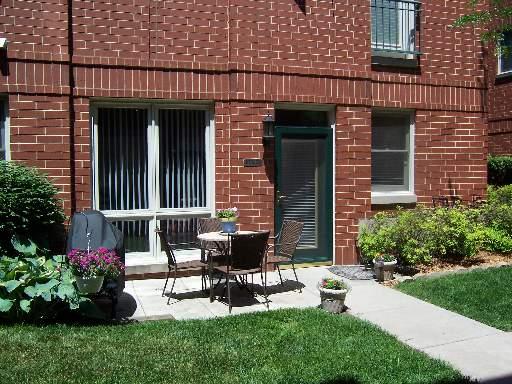 Front view of a brick house with a patio area.