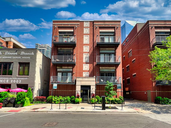 Front view of a multi-story brick building with balconies.