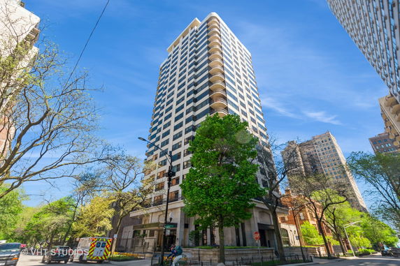 Front view of a tall residential building with multiple balconies.